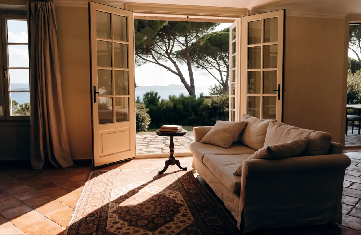 Salon de villa provençale ouvert sur une terrasse et la mer